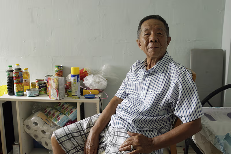a dignified portrait of a lonely man in a rental hdb flat singapore by photographer kelvin lim