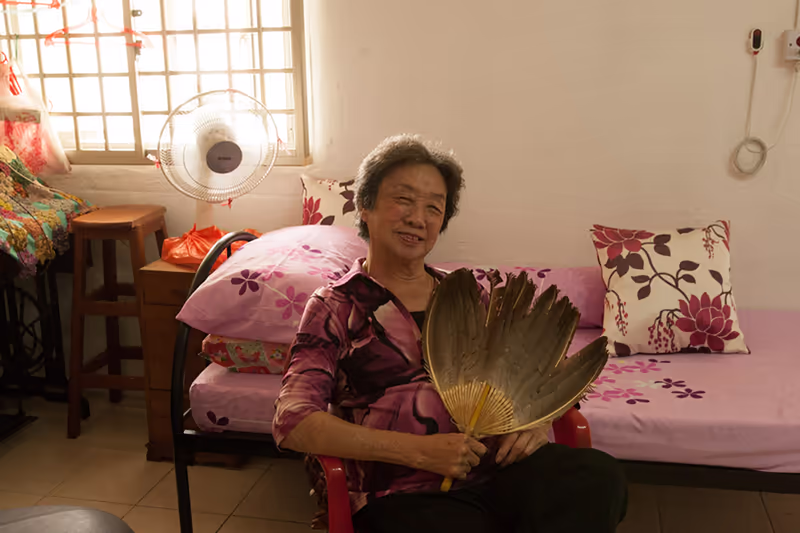 happy old lady smiling like a supermodel in her hdb rental flat home in Singapore, photographed by Kelvin Lim for Portraits of Love project, HNF